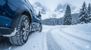 : Auto s kvalitními zimními pneumatikami projíždí bezpečně zasněženou silnicí.