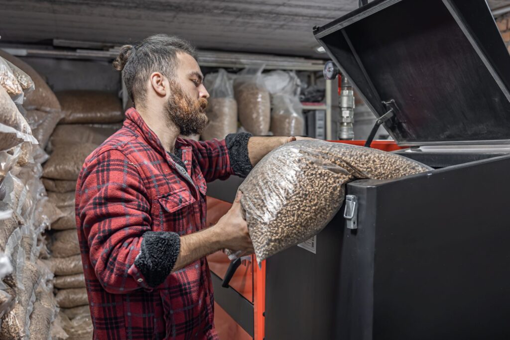 man-loads-pellets-solid-fuel-boiler-working-with-biofuels-economical-heating