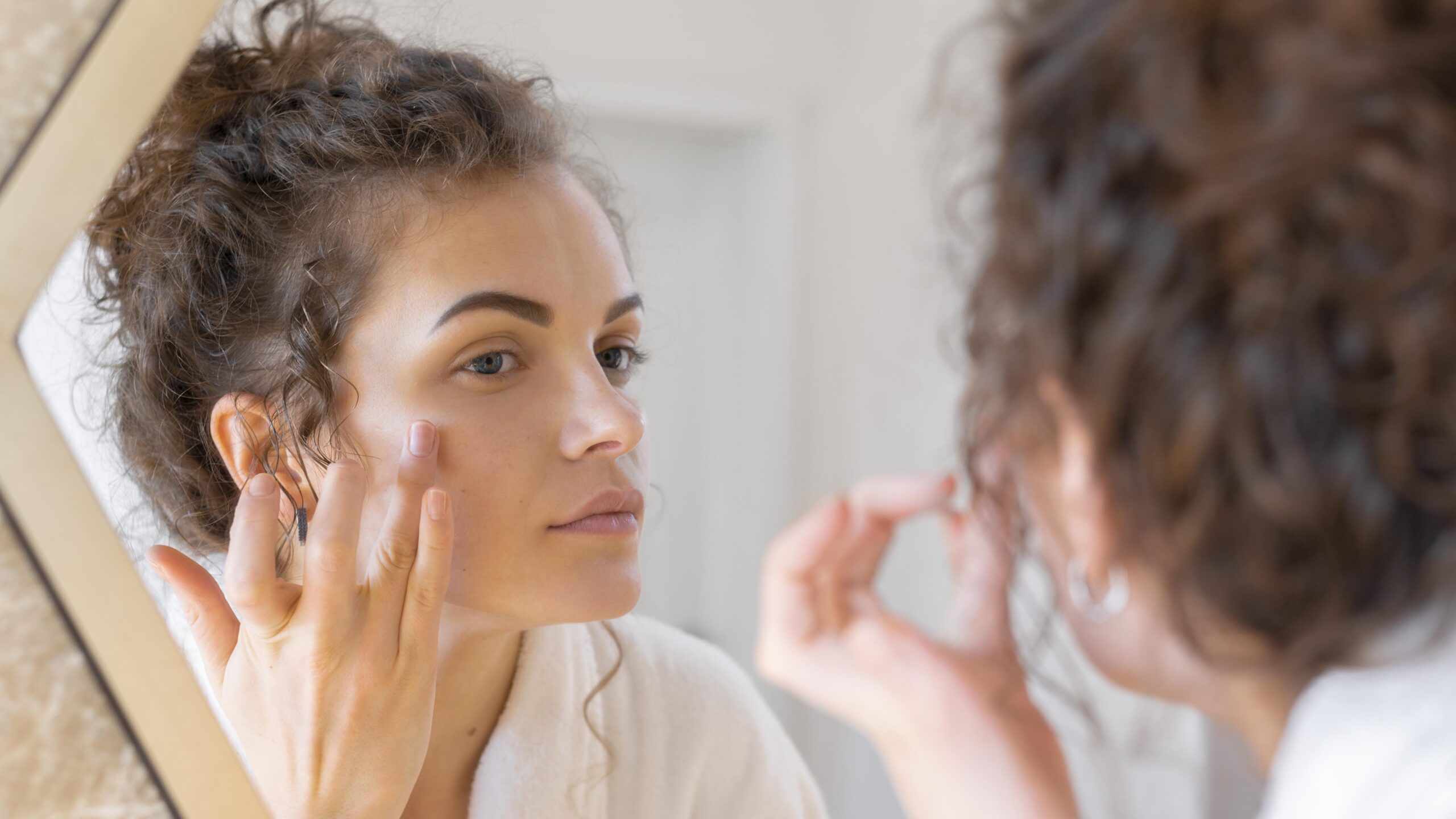 woman-looking-mirror-doing-beauty-face-routine