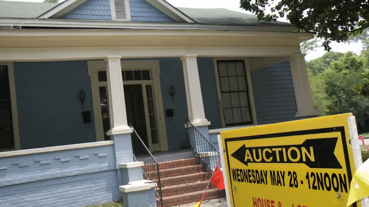 home-being-auctioned-off-blue-home-white-front-porch-yellow-auction-sign